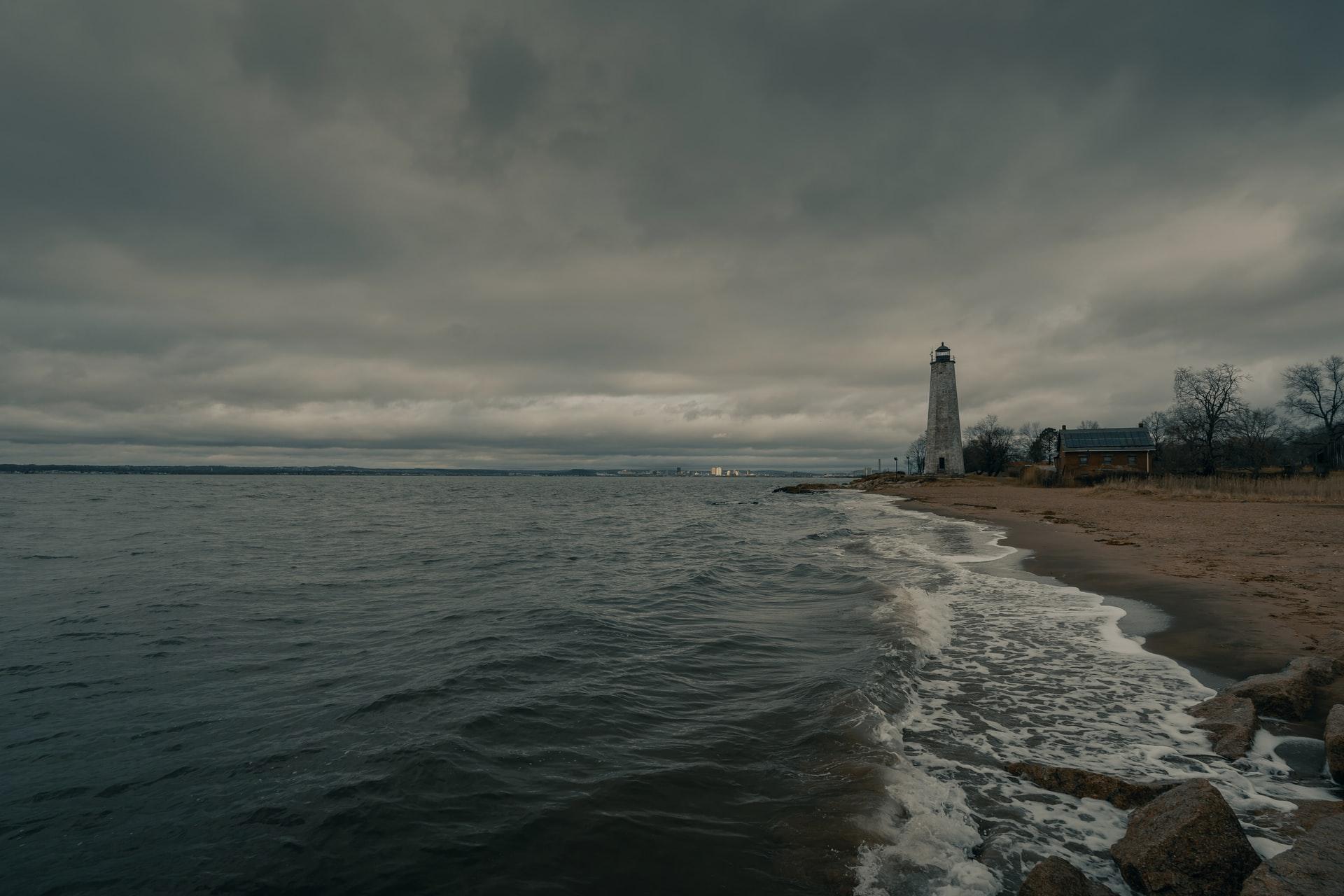 视图灯塔,纽黑文与大海左边和右边的海滩。