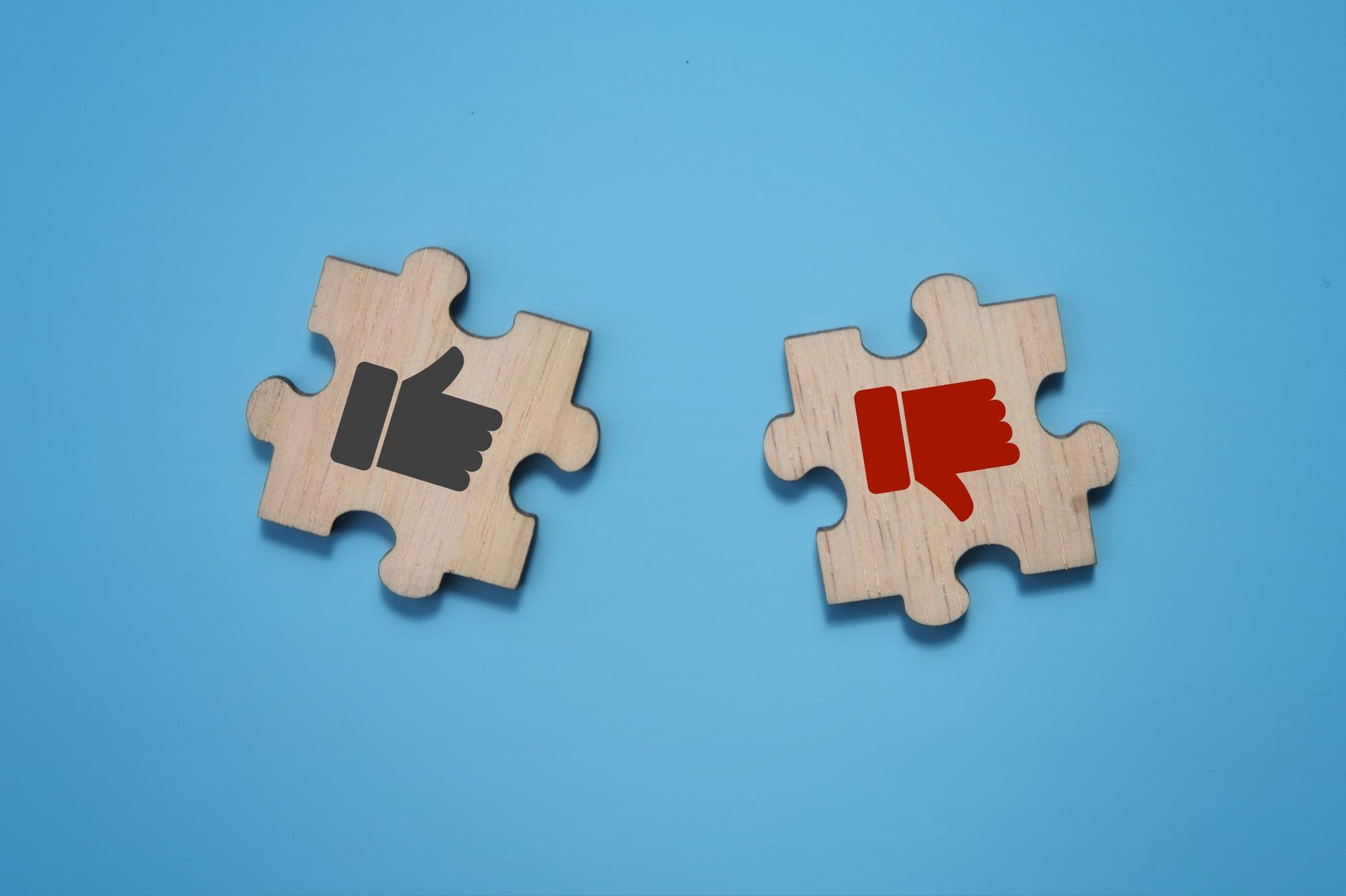 黑色竖起大拇指的象征,一个红色的责备在两个木拼图在蓝色的背景上