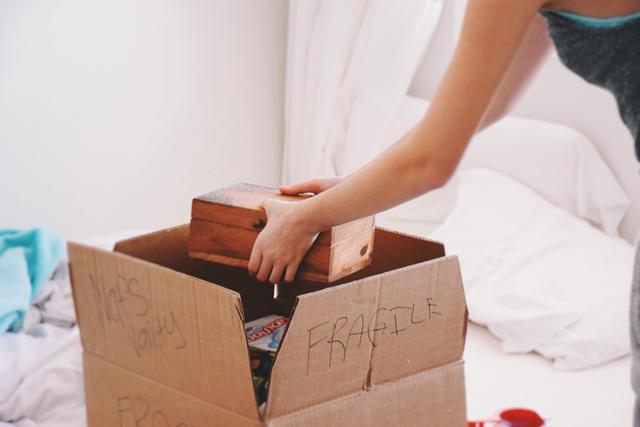 person unpacking box labeled fragile (@JulieK via Twenty20)