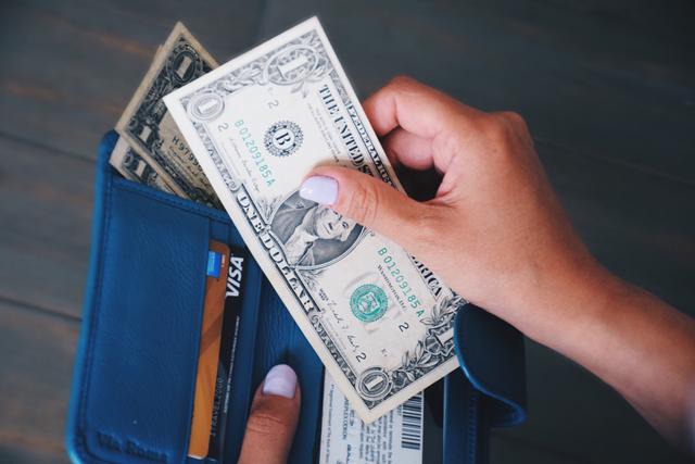 Holding wallet and money (Photo by JulieK via Twenty20)