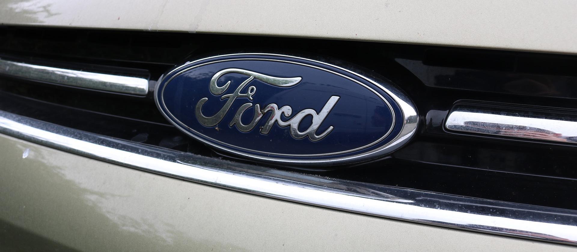 Closeup of Ford logo on the front of a car.