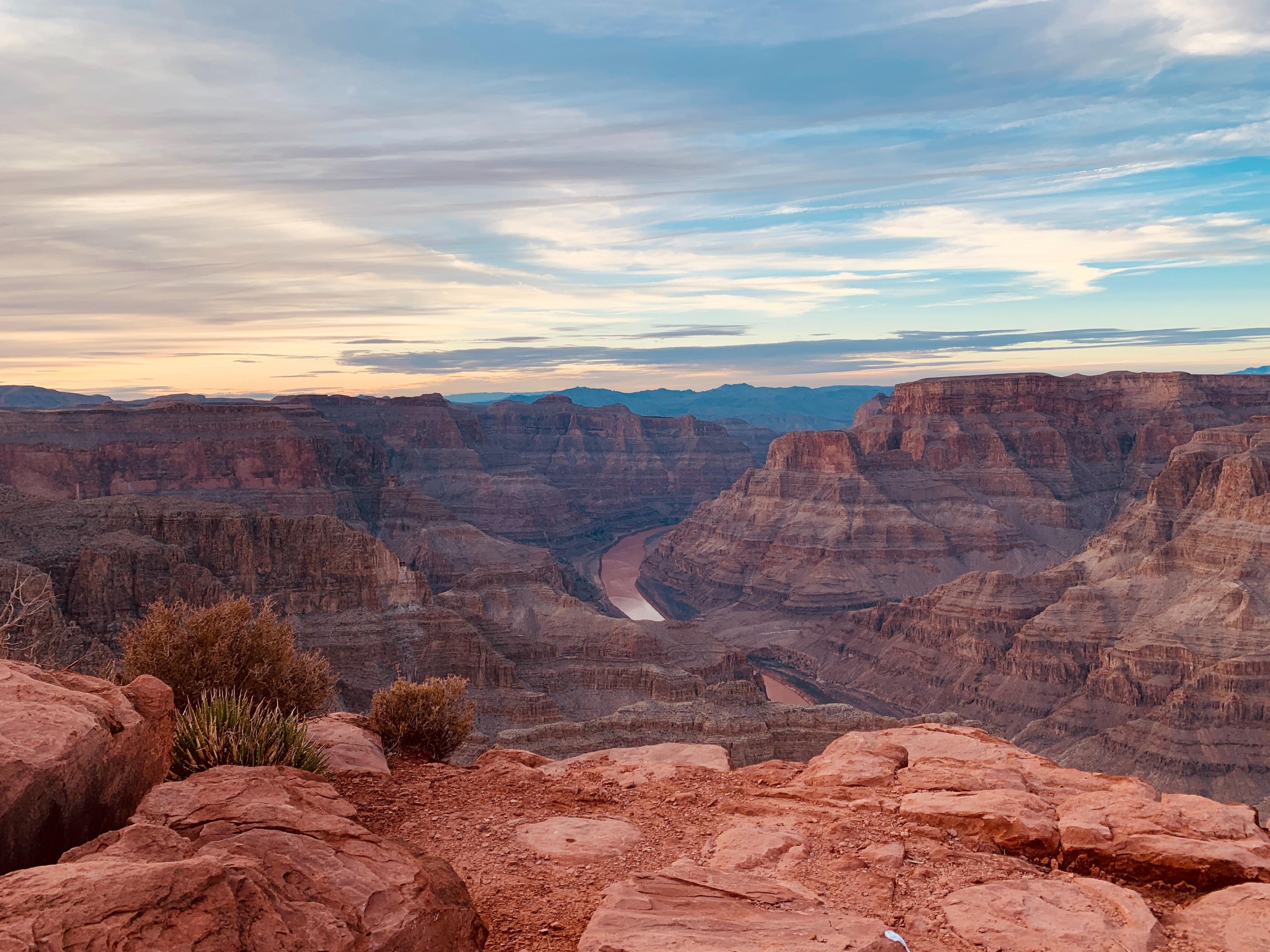 A view of the Grand Canyon under blue cloudy skies.