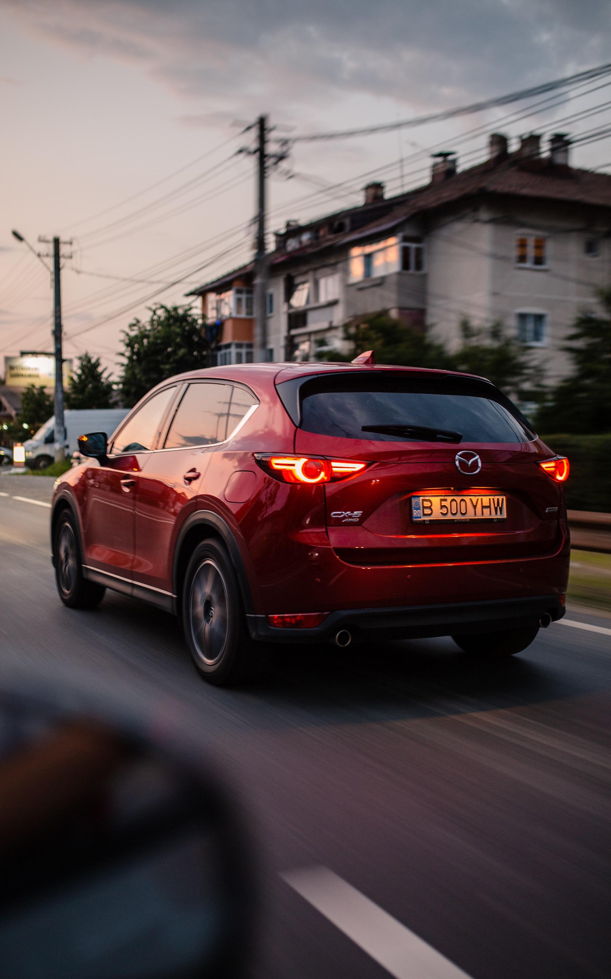 Image of a red mazda cx 5 driving through a residential area. 