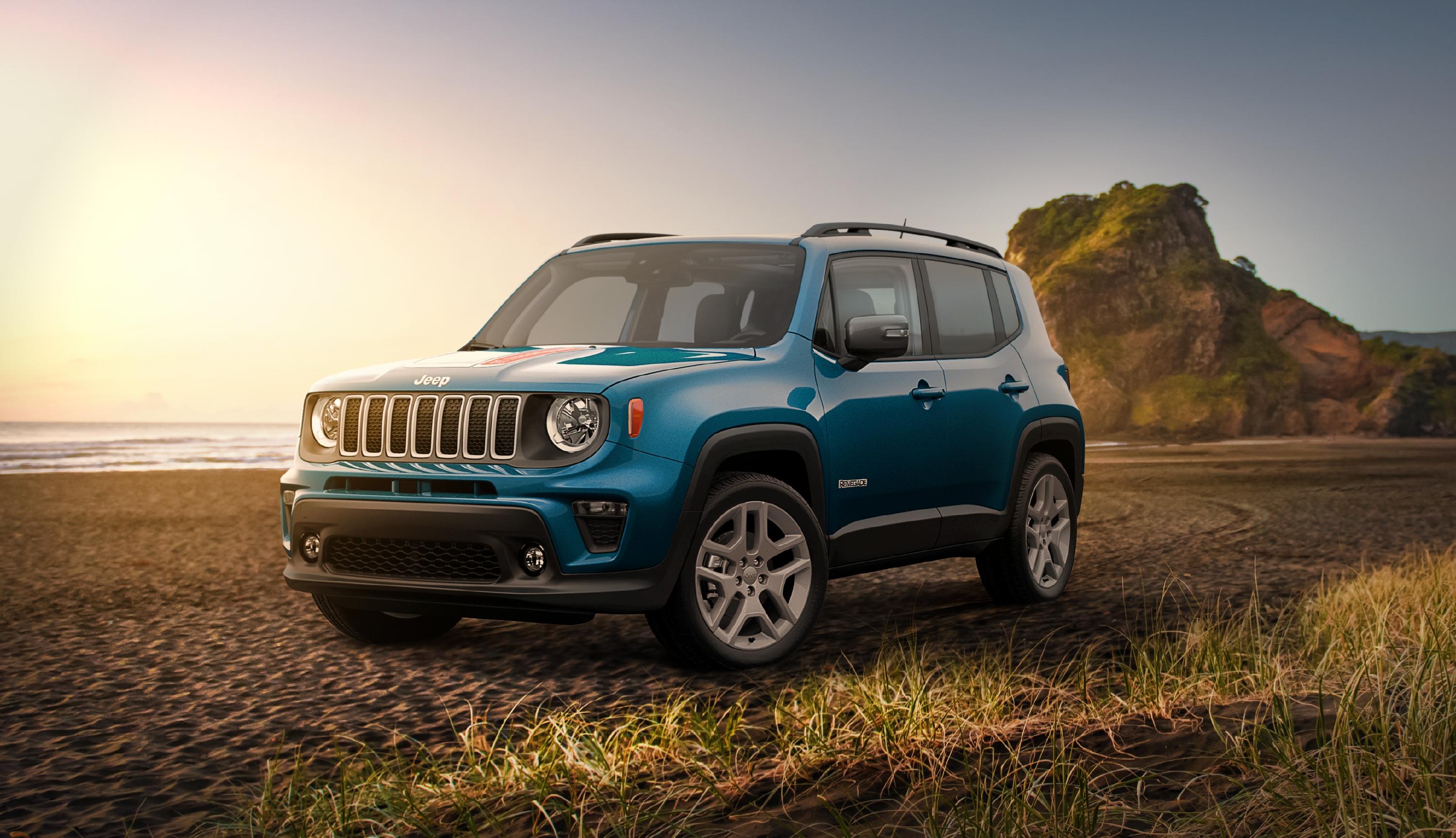 Image of a blue Jeep Renegade parked on the beach in the sand near the ocean.