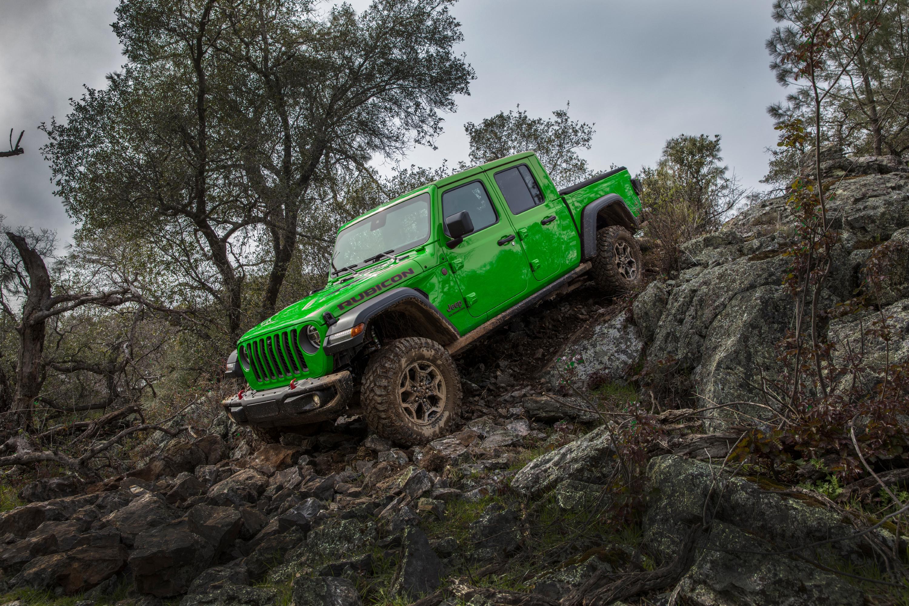 Image of a gecko green Jeep Gladiator driving down rocks.