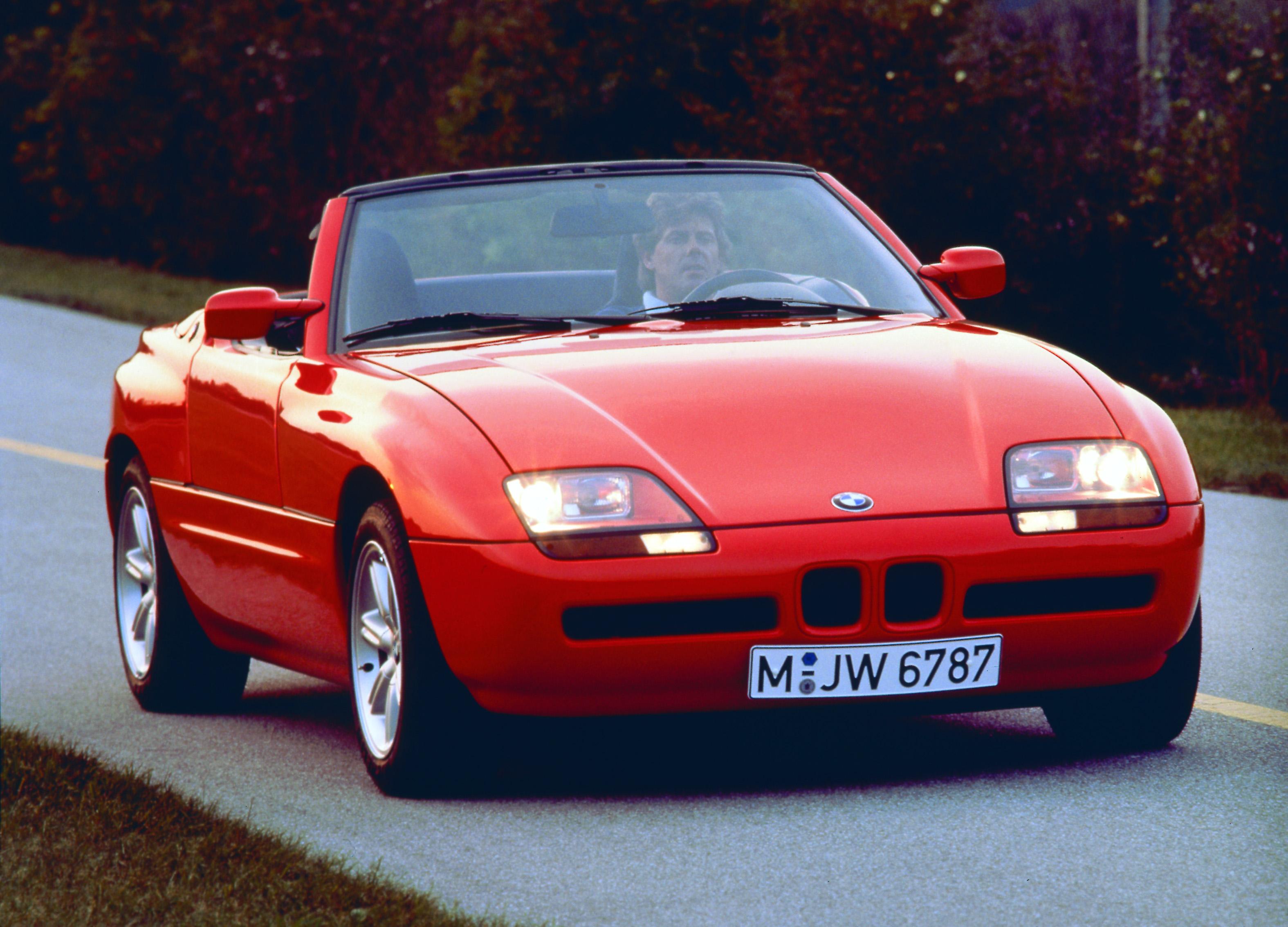 A red BMW Z1 driving down the street