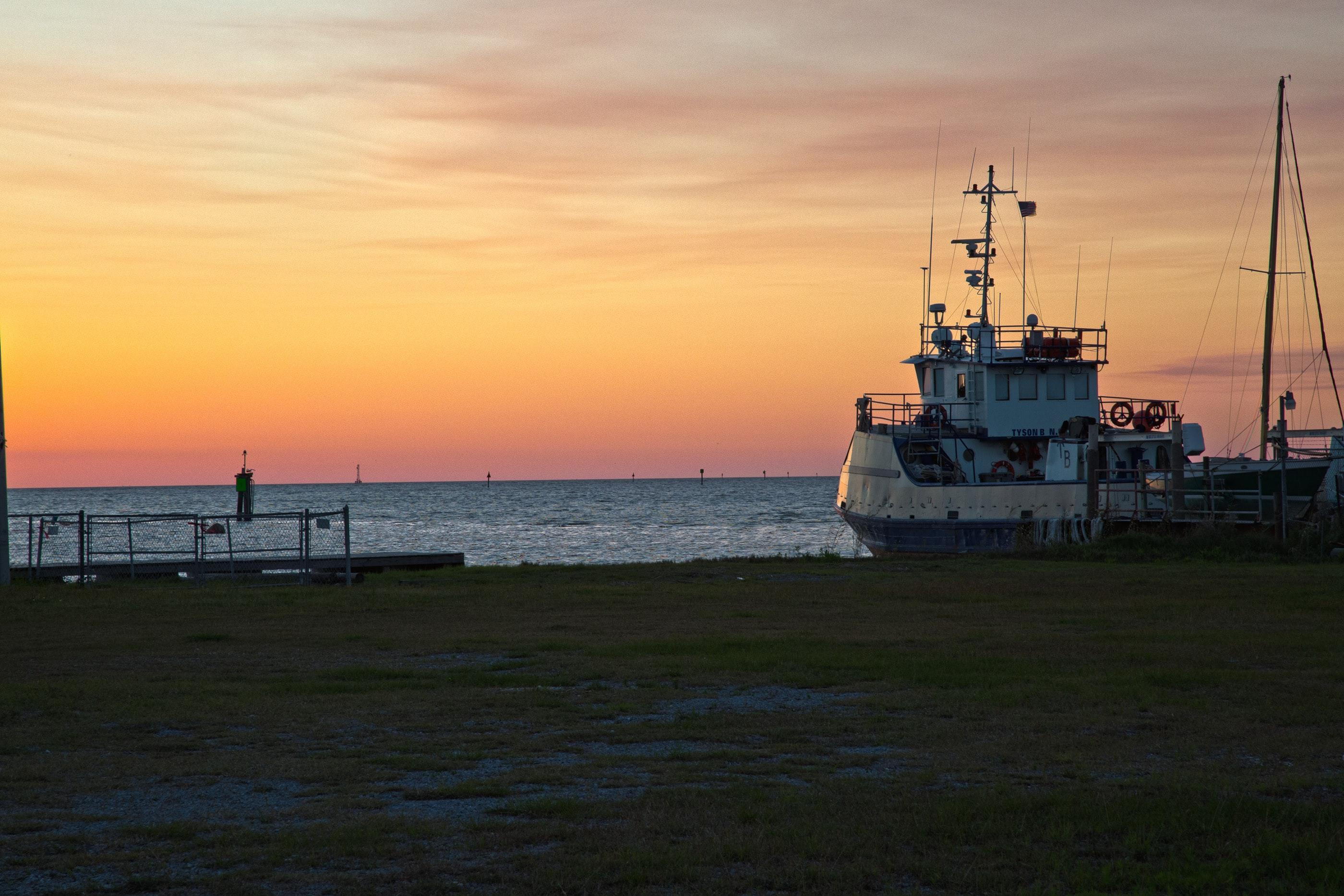 A view of a boat at sunset in Dauphin Island Alabama.