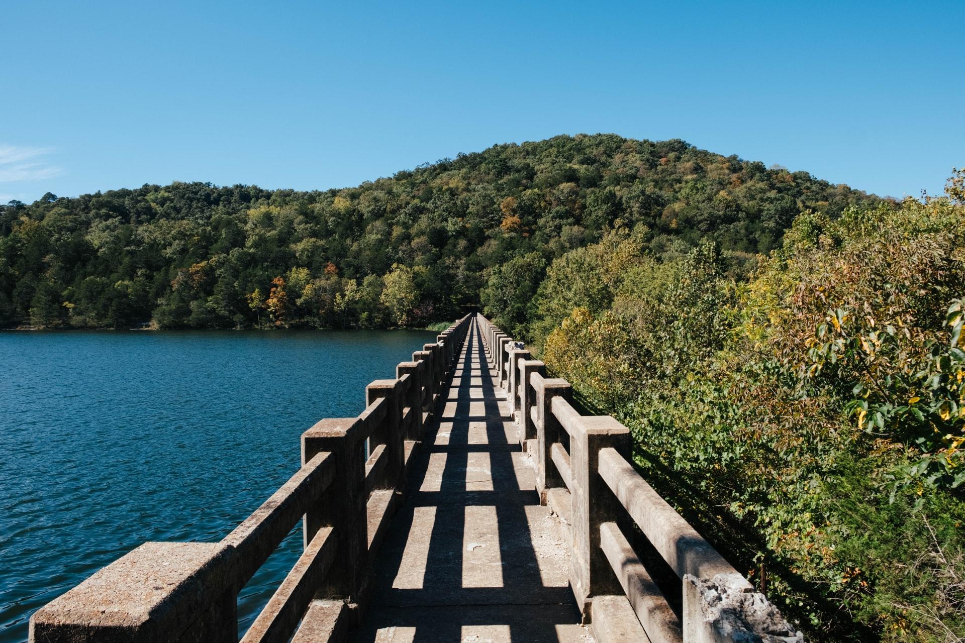 A wooden bridge dividing a lake an the woods in Eureka Springs.