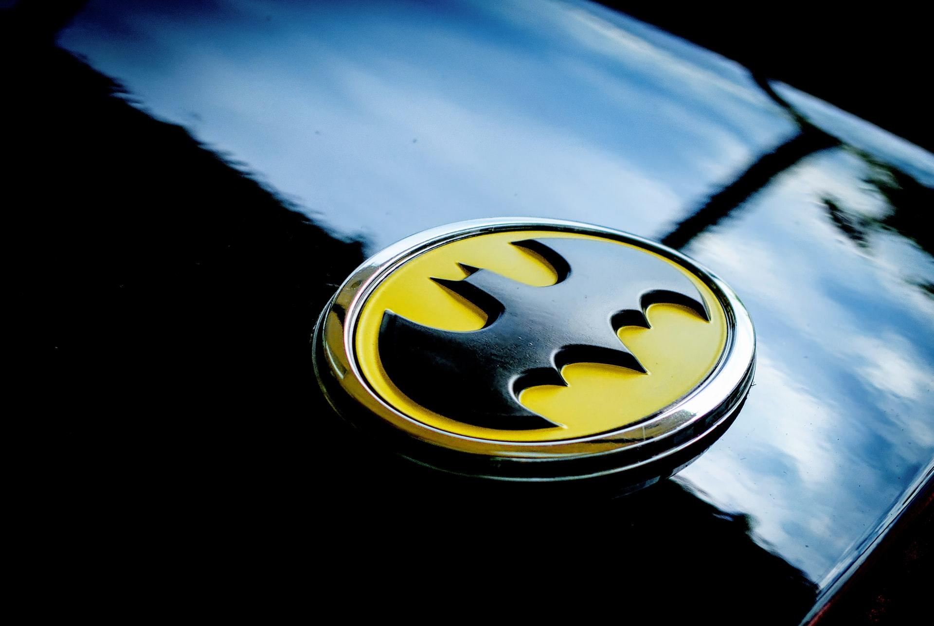 A Batman logo on the hood of a black car.