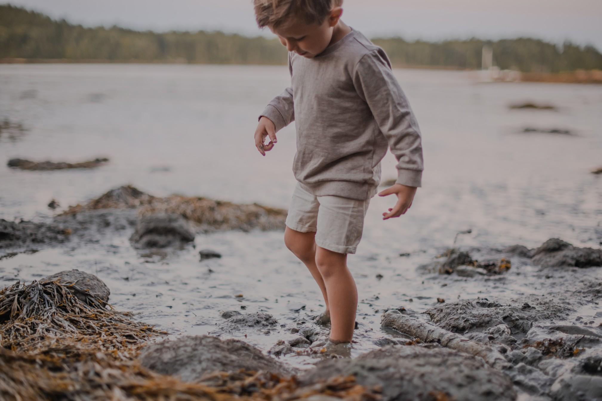 A child playing in the tidal mudflats in Maine.