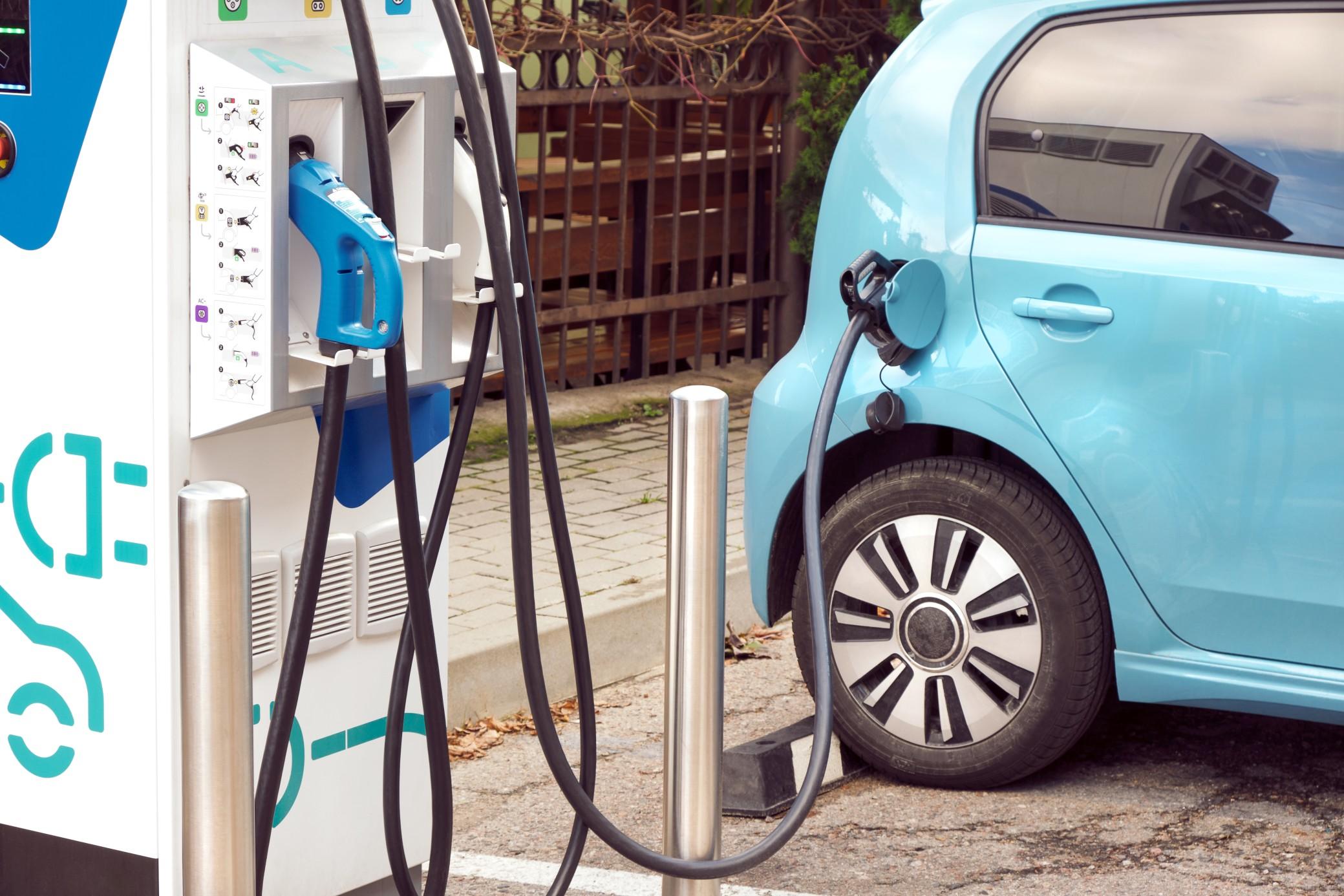 A blue electric car being charged 