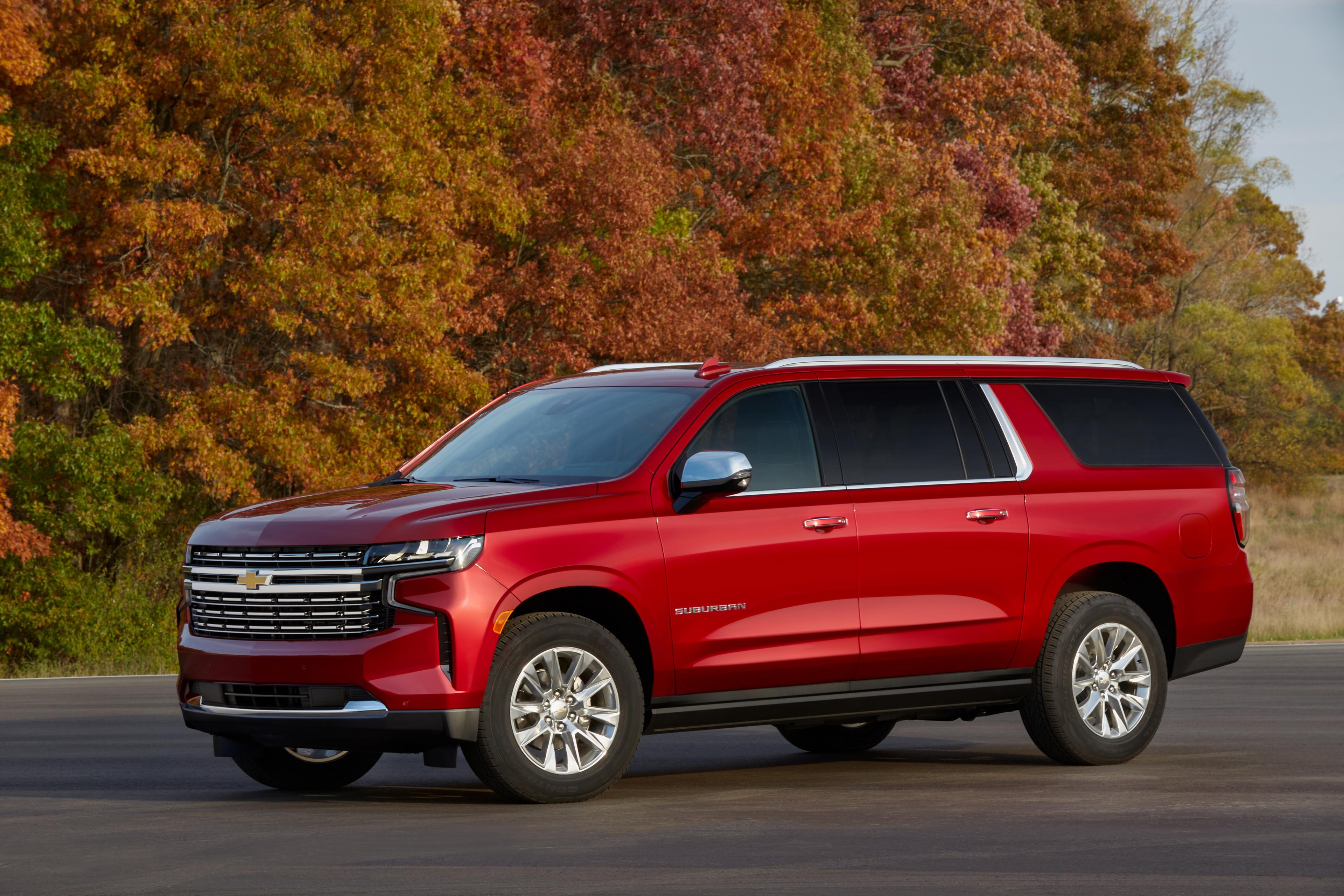 A red 2022 Chevrolet Suburban parked outside next to trees