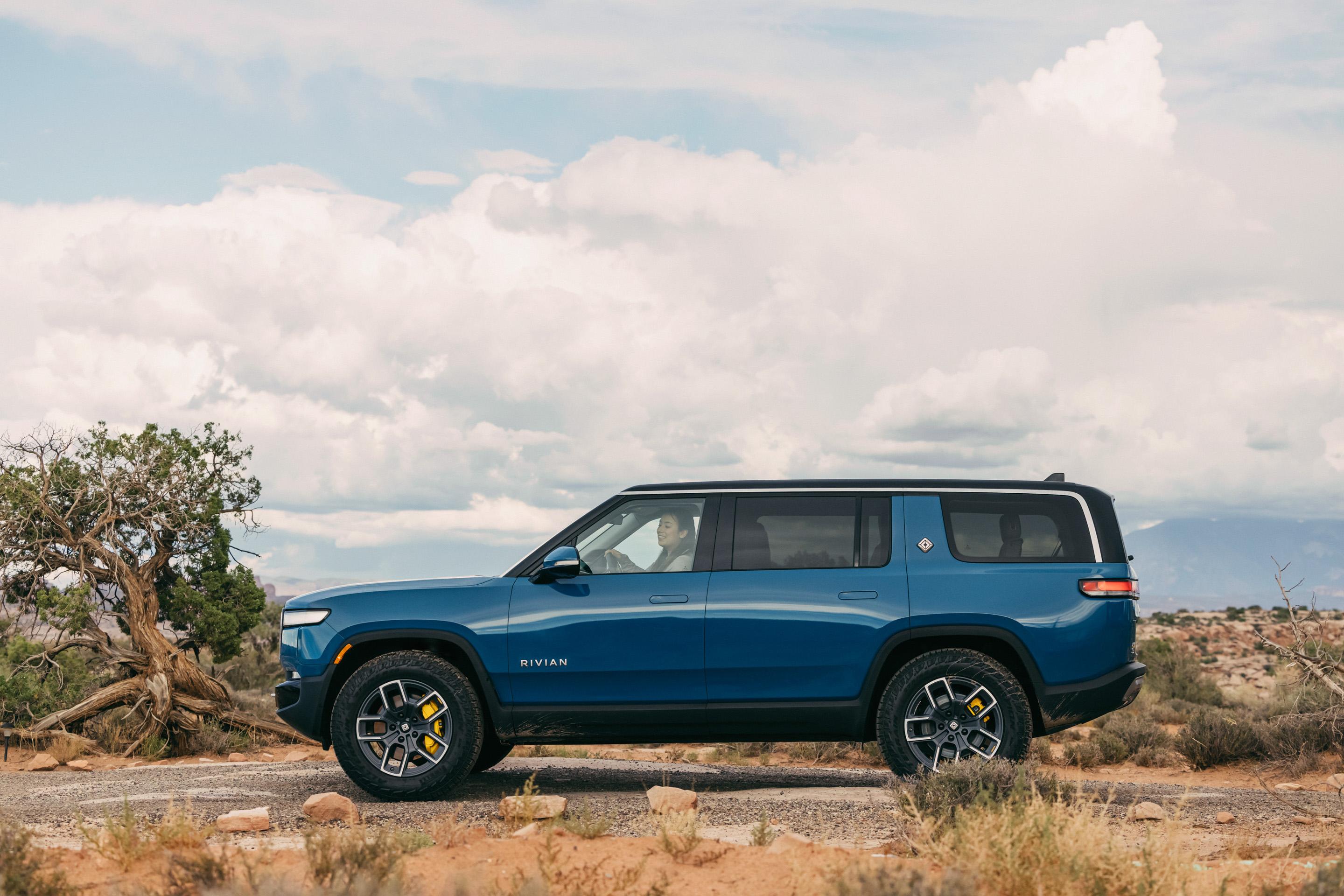 A blue 2022 Rivian R1S outside on a deserted road