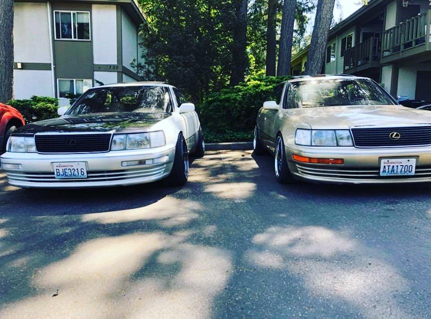 Two older Lexus LS 400 sedans parked outside a house.