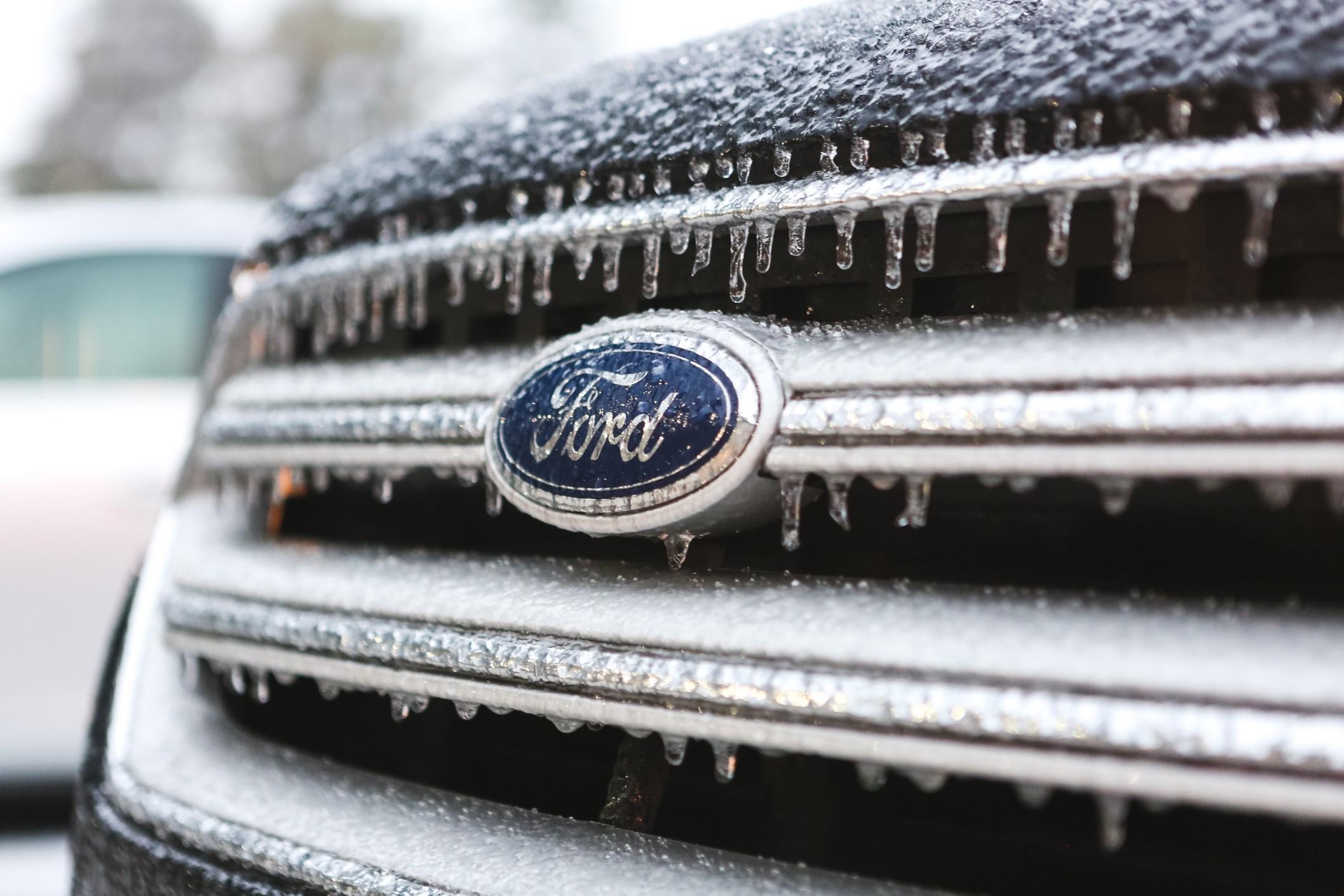 Closeup of the front of a Ford car that's icy