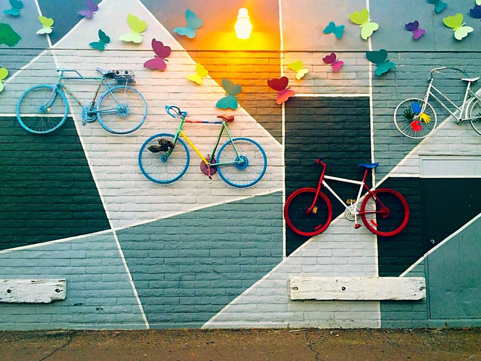 几何墙上壁画色彩斑斓的蝴蝶和自行车。