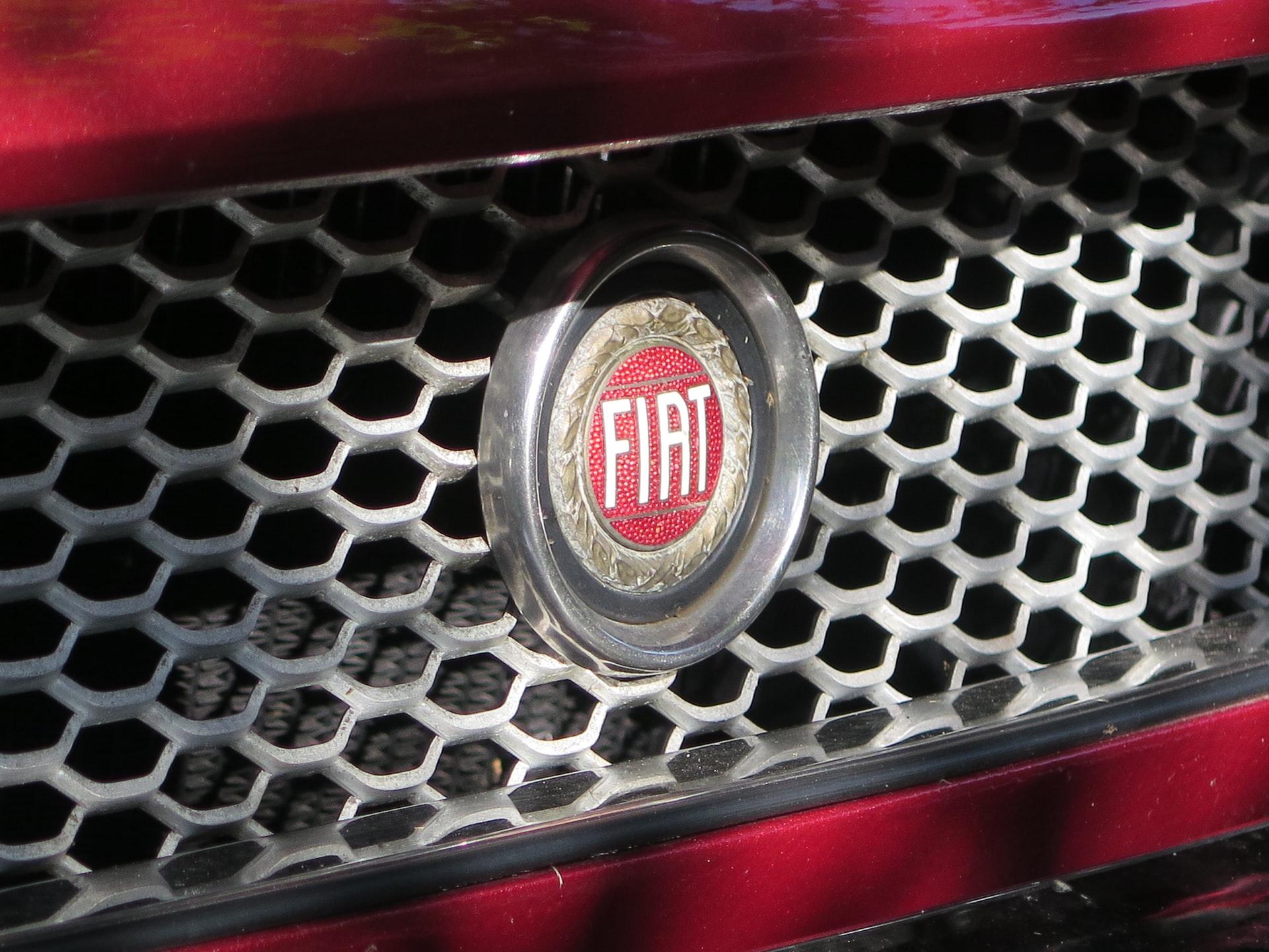 Close-up of a red fiat’s grille with a red Fiat nameplate