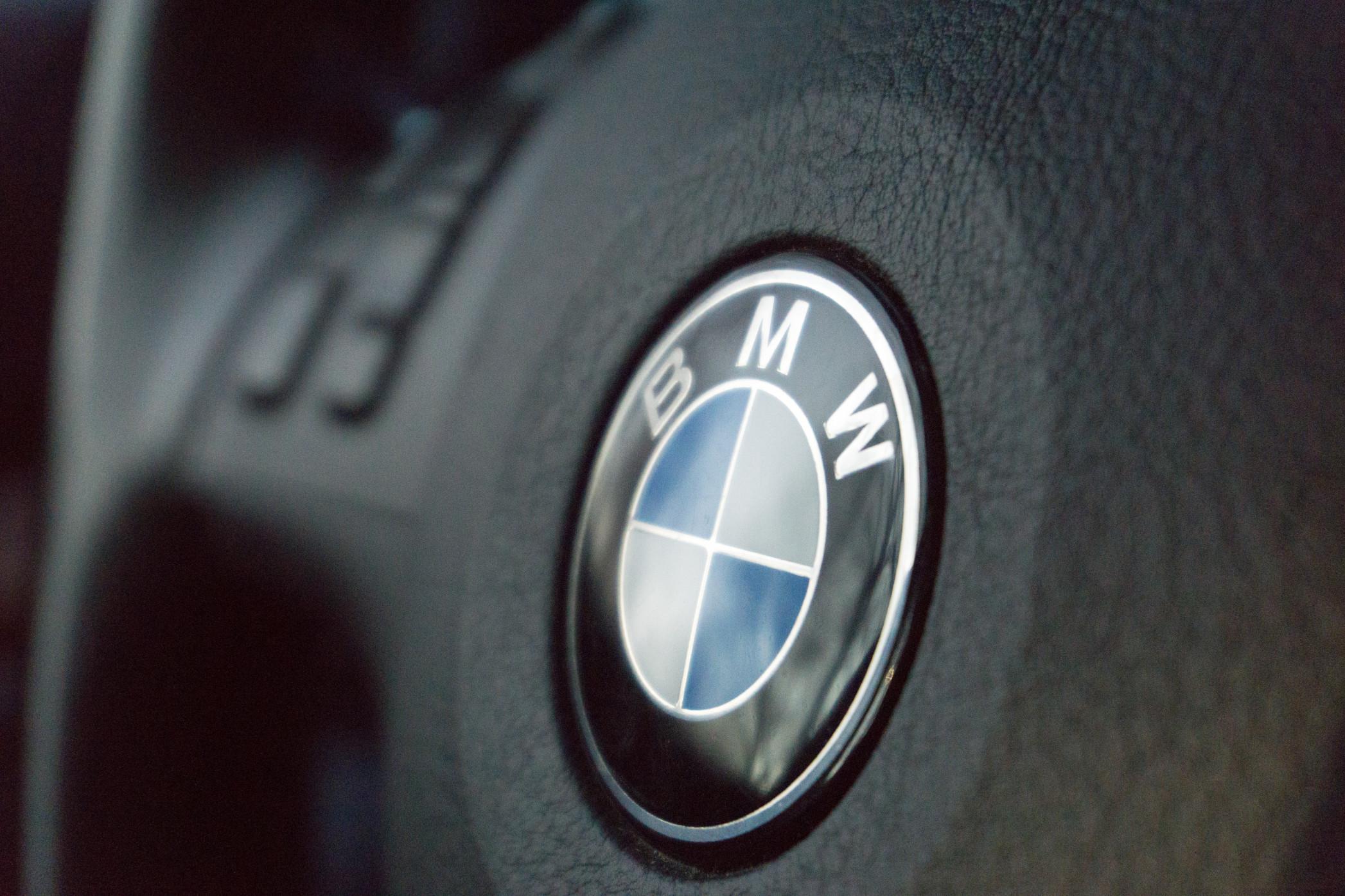 A closeup of a BMW logo on a steering wheel.