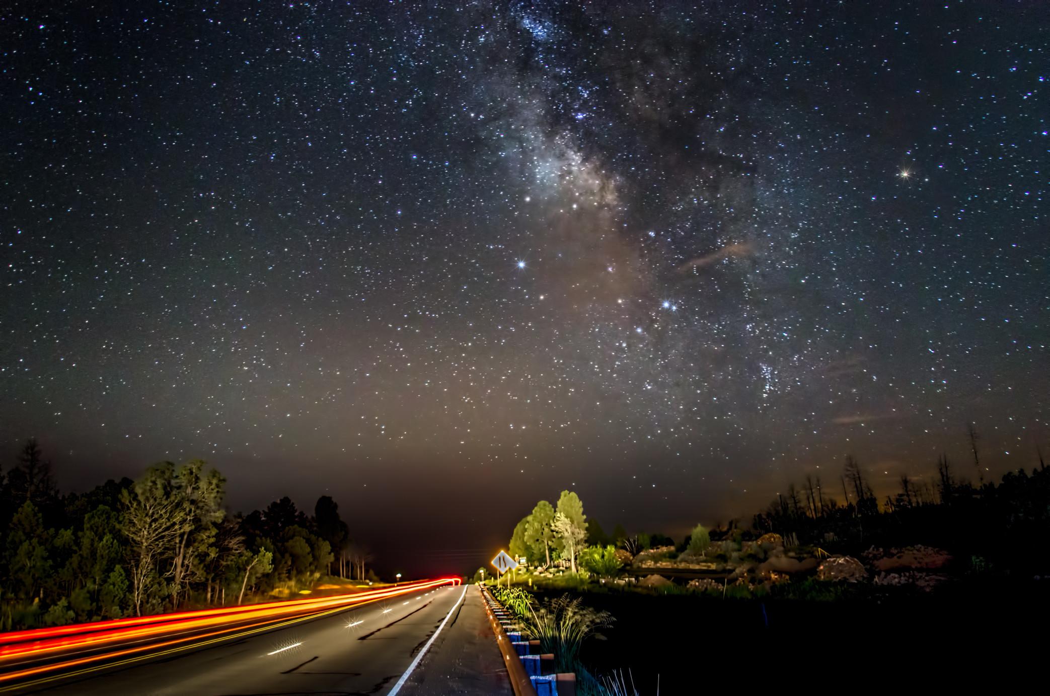 View of a stary sky over a road going through the desert. 