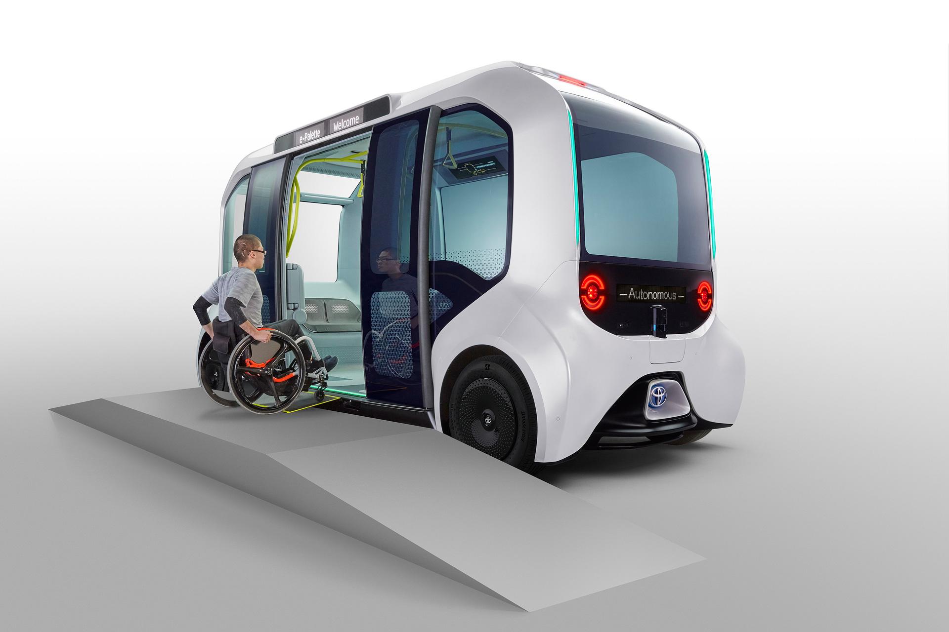 A person in a wheelchair going on to a Toyota self driving bus.