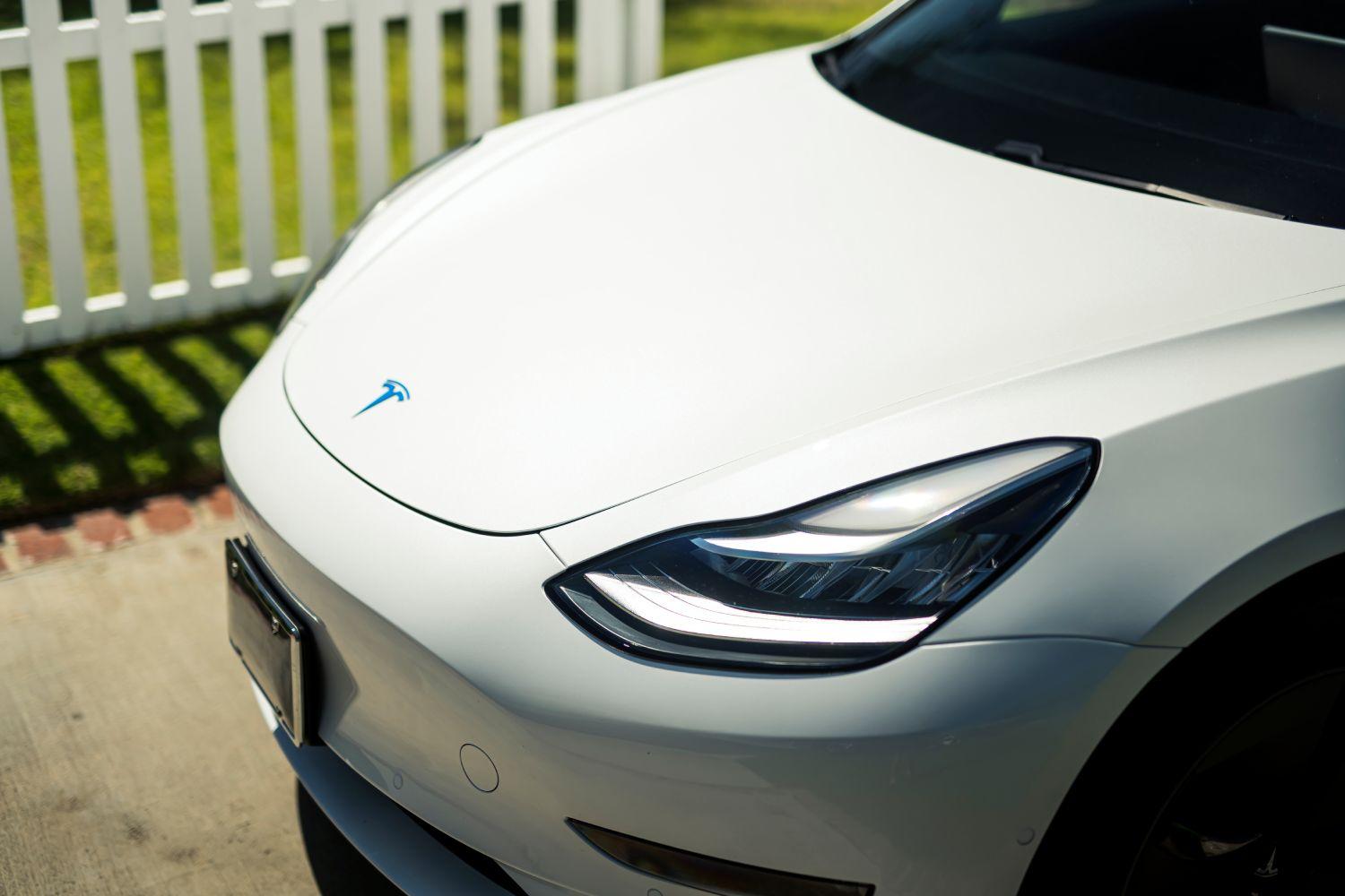 White Tesla hood with blue Tesla insignia